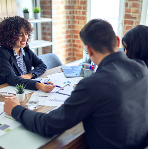People sitting across conference room table while looking at paperwork